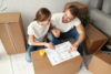Couple discussing house plan sitting on floor with moving boxes